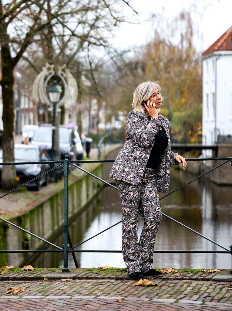 Melanie van De MEL Methode staat op een brug en belt.